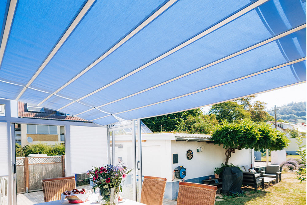 View from below of the blue shading and the white roof profiles of the TOPAS solar veranda patio cover.
